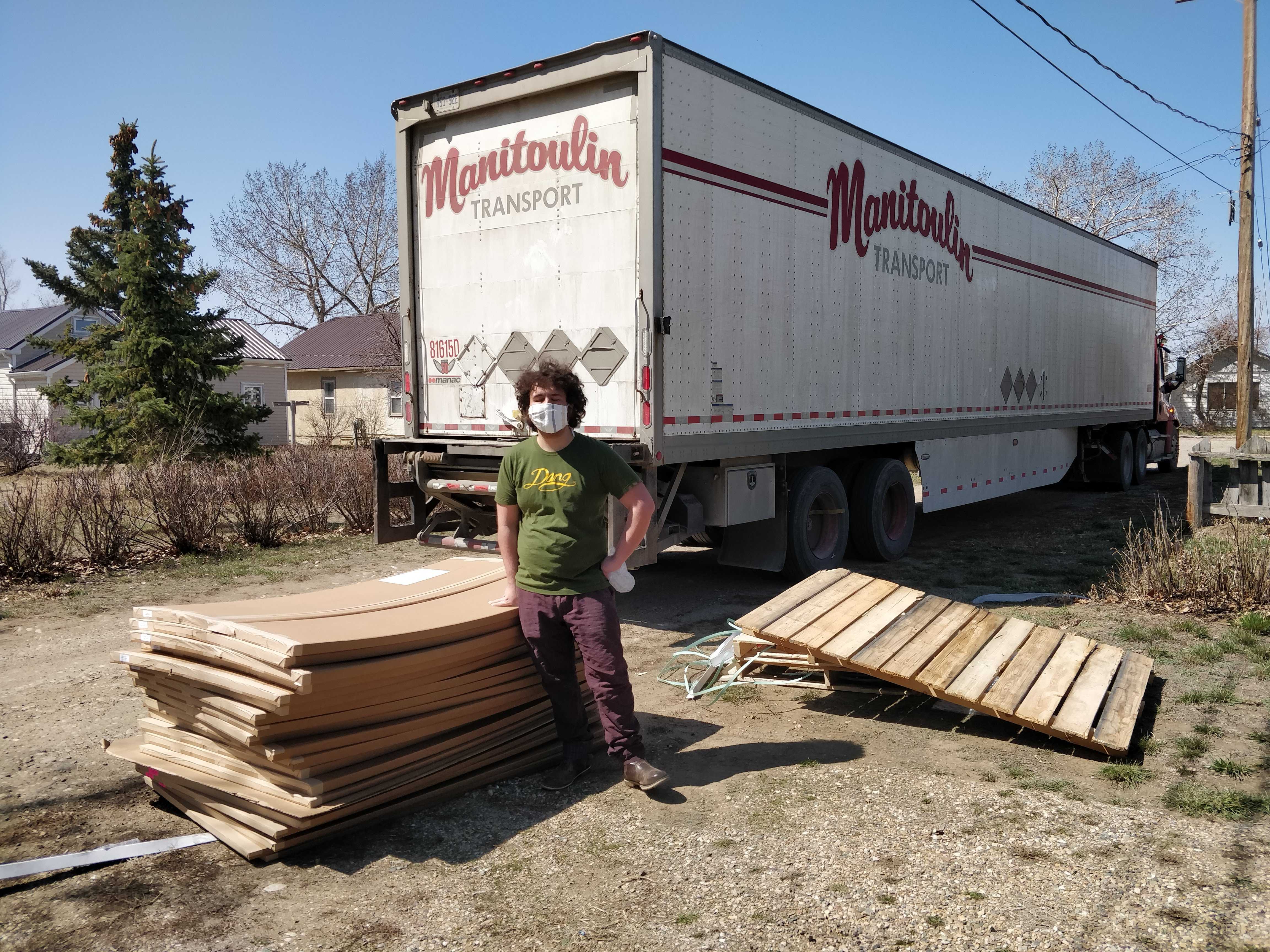 A man standing next to a truckload of maps.